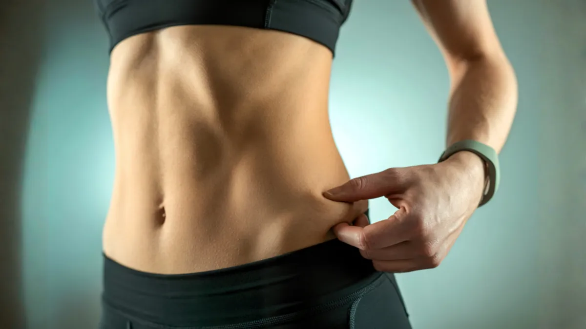 Bir kişinin bel çevresini mezura ile ölçerek bel kalça oranı hesaplaması yapması.